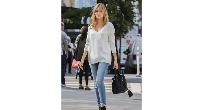 Hailey bär en oversized vit tröja med jeans – en riktigt snygg look.
